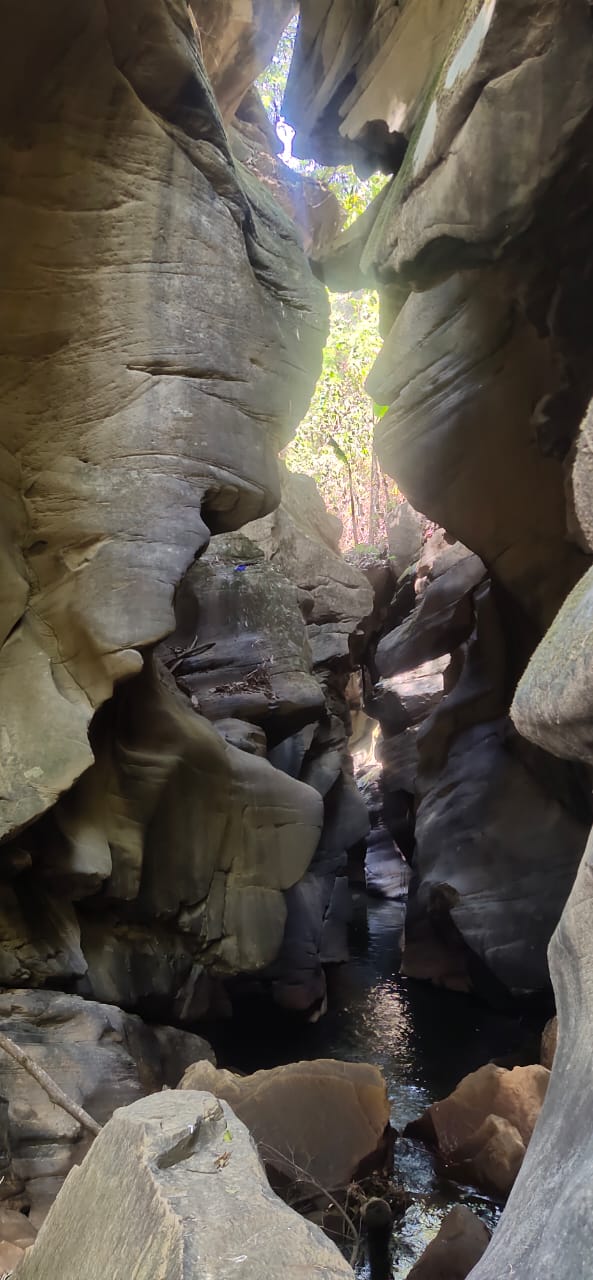 A narrow rock gorge with water flowing through sculpted sandstone walls near Dzüleke